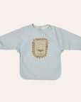 OYOY Mini Lobo Lion Cape Bib in Ice Blue with long sleeves and lion illustration
