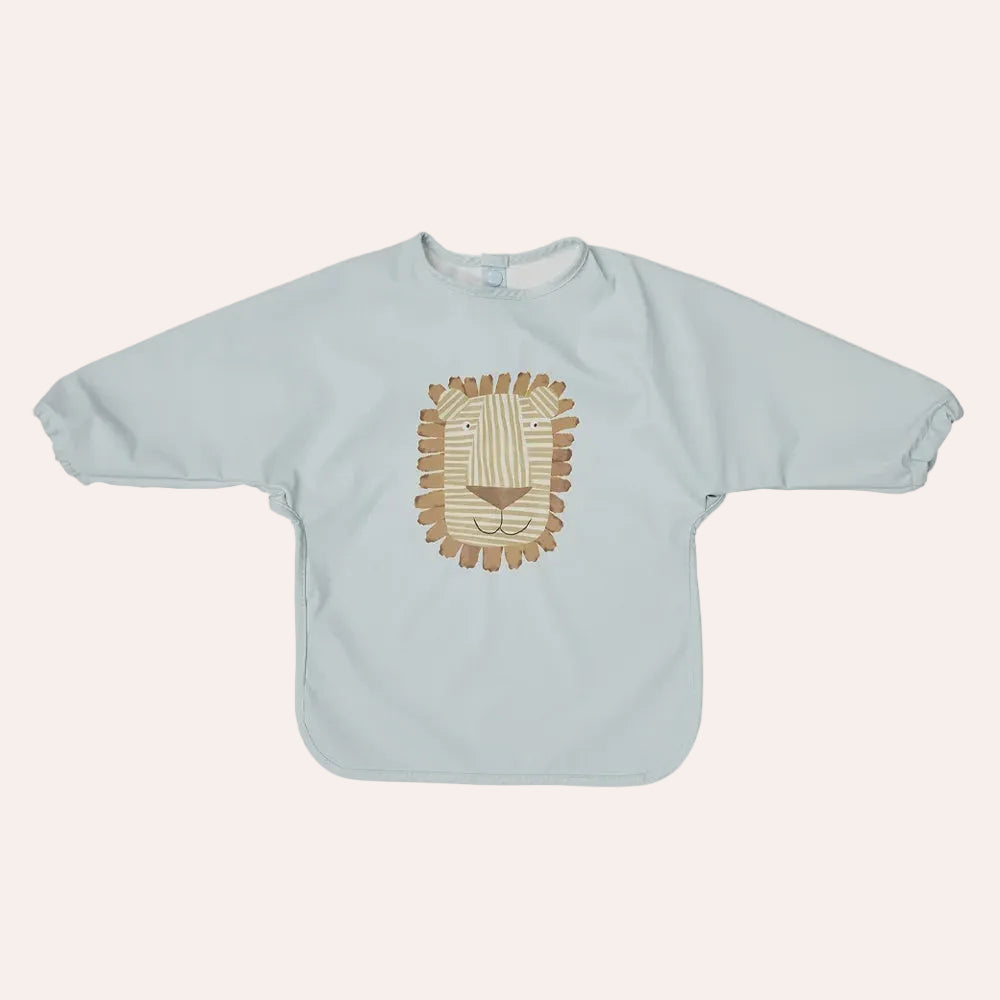 OYOY Mini Lobo Lion Cape Bib in Ice Blue with long sleeves and lion illustration